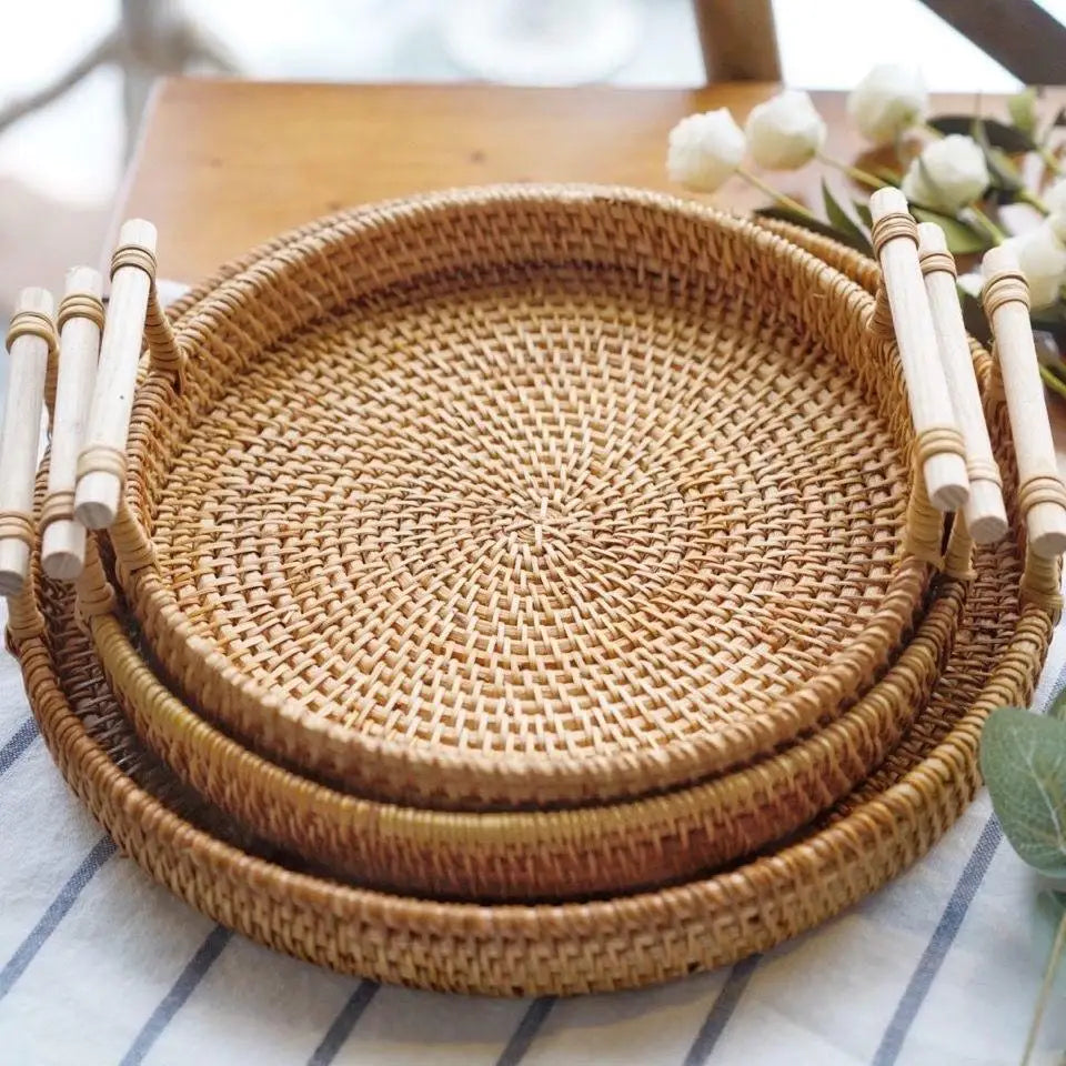 Set of woven rattan trays on a striped fabric background