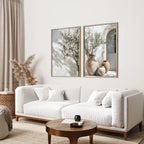 Modern living room with a white sofa, wooden coffee table, and two framed artworks on the wall.