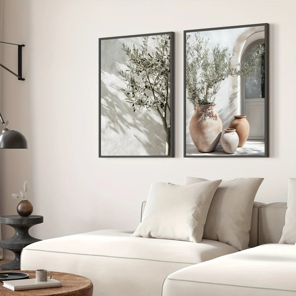 Two framed pictures of plants on a wall above a sofa in a living room.