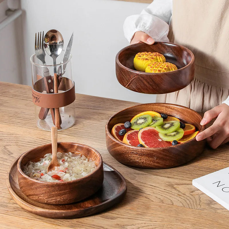 Wooden tiered salad server with various dishes on a wooden table.