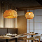 Restaurant interior with wicker pendant lights and wooden tables.