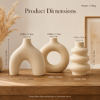 Three beige ceramic decorative vases displayed on a wooden surface with overlaid dimension labels and the heading 'Product Dimensions.' The scene includes a softly styled interior background with dried grass and a framed print, but the primary purpose of the image is to communicate size information rather than simply show the product, so subject_type is Measurement Chart.